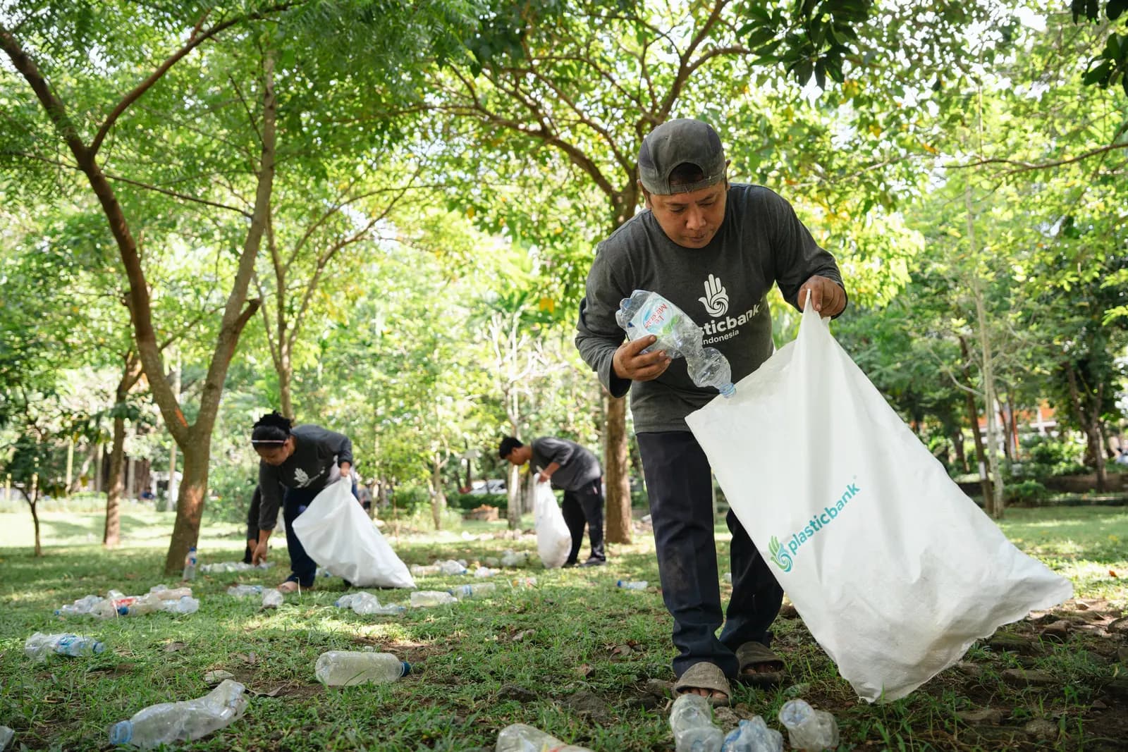 Collectors gathering plastic bottles in a park in Denpasar, Bali
