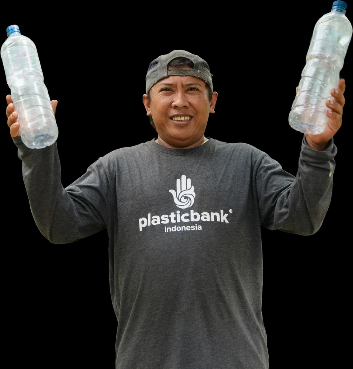 Toyib, a Plastic Bank collection member in Bali, holding up two bottles