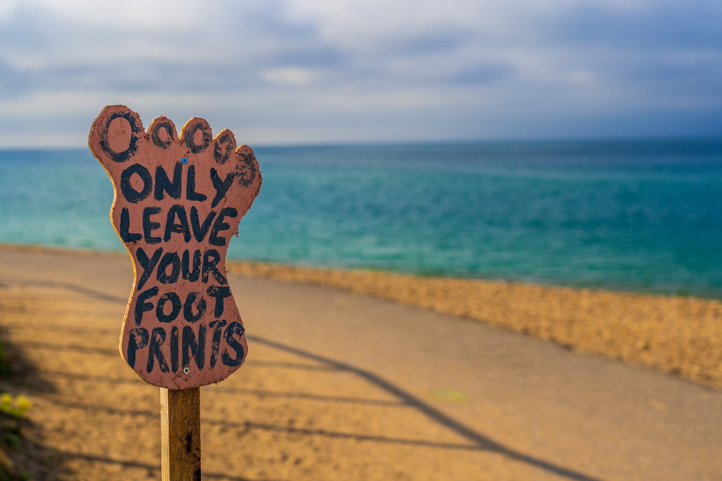 Only leave your footprints signage by the beach