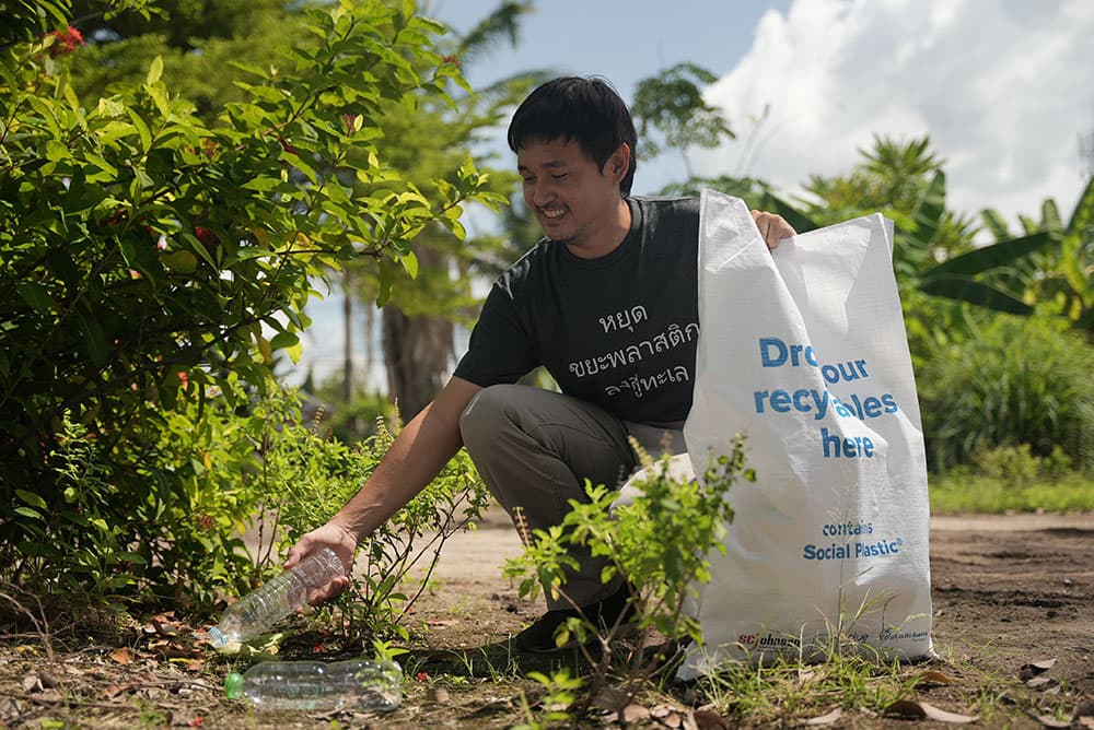 A collection community member in Thailand is picking a plastic bottle
