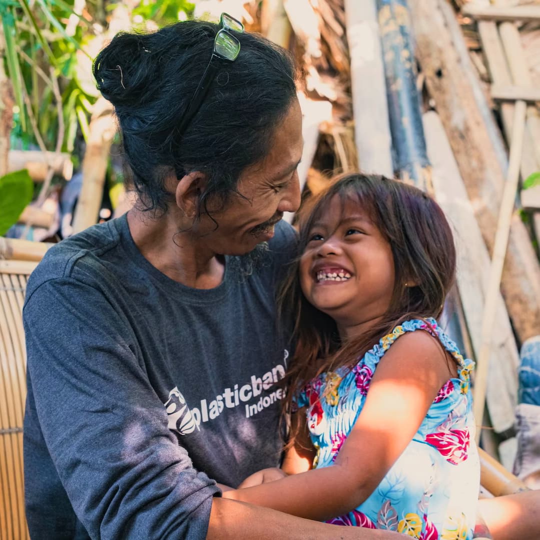 Plastic Bank collection member hugs young family member